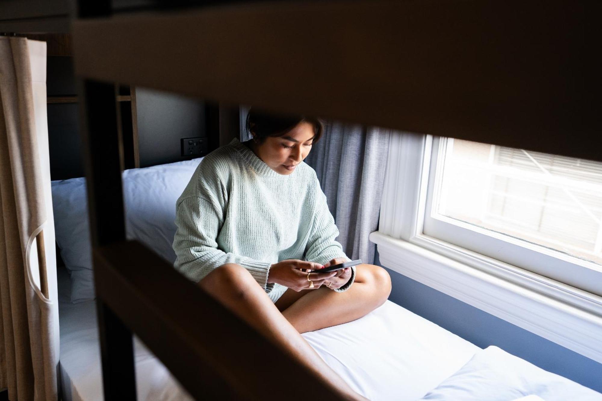 بيت شباب واي إتش إيه روتوروا المظهر الخارجي الصورة A woman sitting on a bunk bed